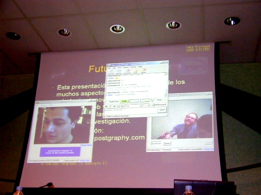Foto de un momento de la videoconferencia con Fabio Arciniegas, en la pantalla puede verse parte de su presentación, la imágen de Fabio Arciniegas y la de Charles McCathieNevile haciéndole una pregunta por medio de la webcam.