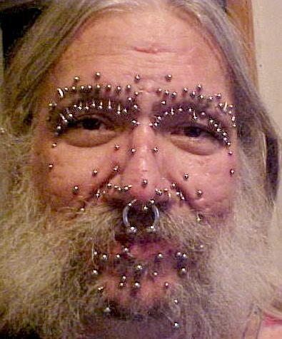 Foto de un hombre con muchos 'piercings' en la cara.