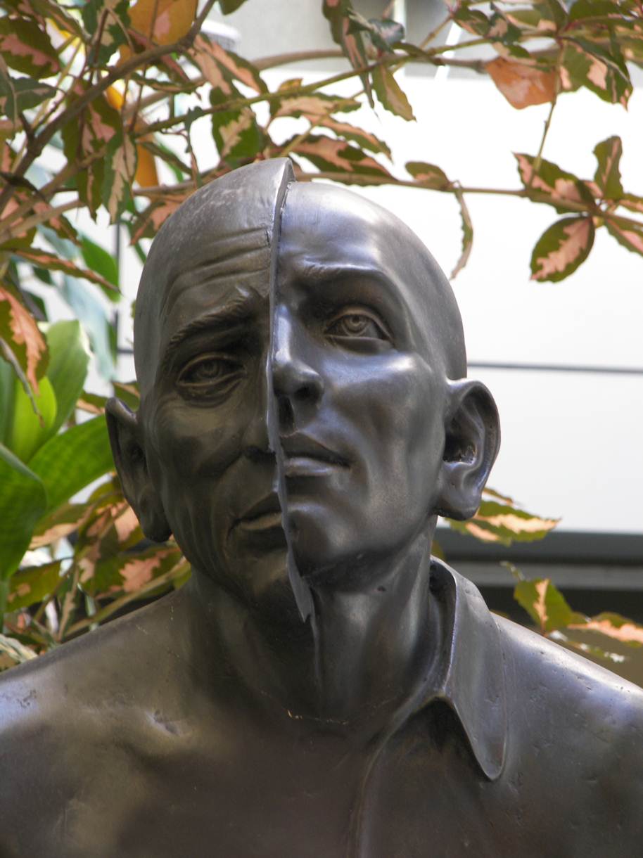 Escultura, mitad persona mayor, mitad persona jóven.